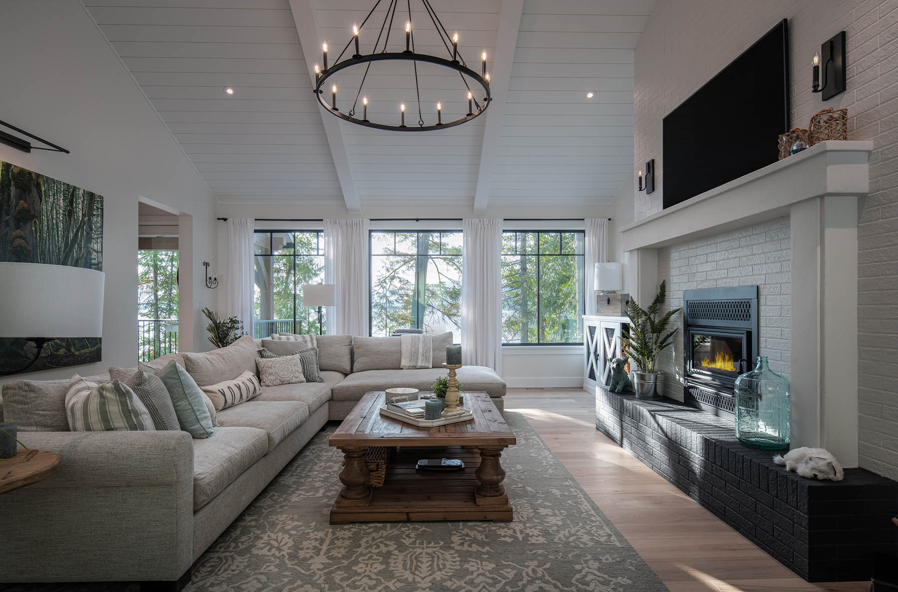 Elegantly designed living room with a cozy fireplace, plush sectional sofa, and large windows offering ample natural light.