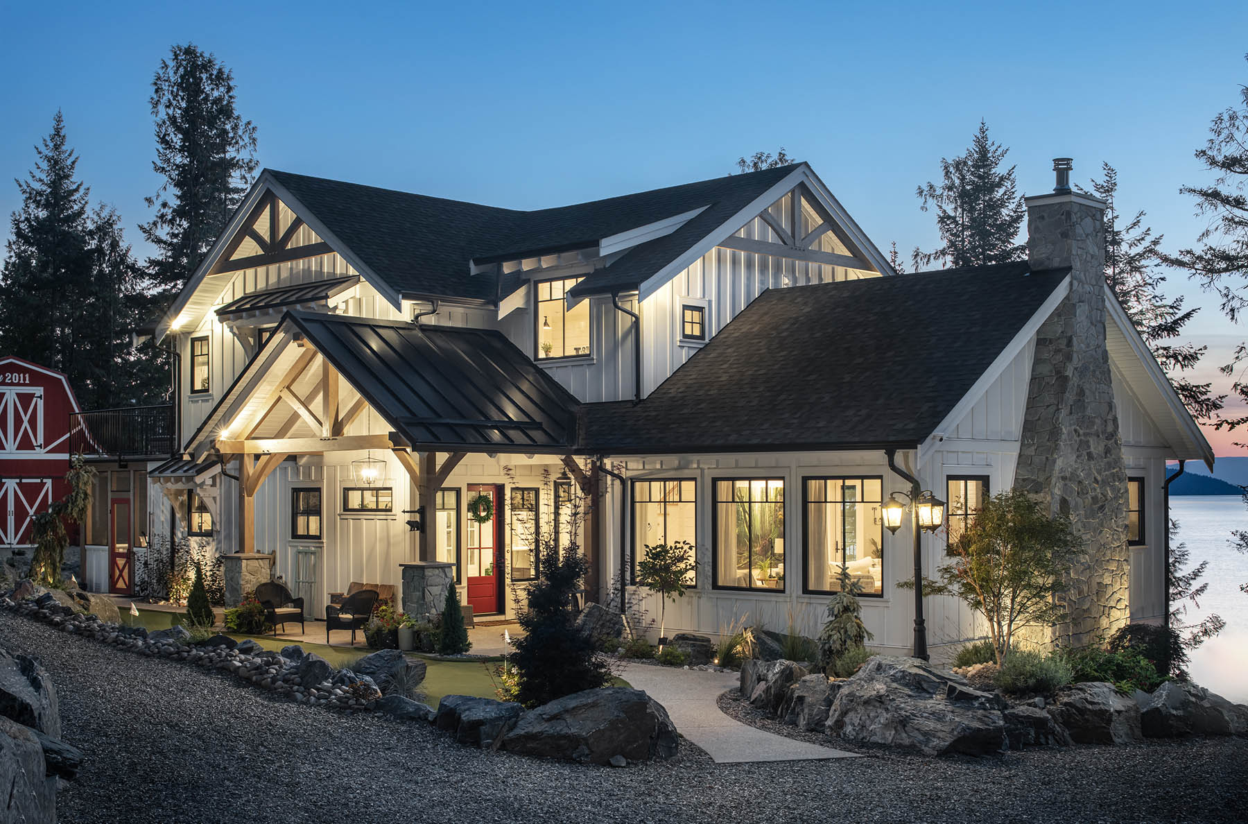 An idyllic evening setting showcasing a charming waterfront home with a classic design and warm, inviting lights.